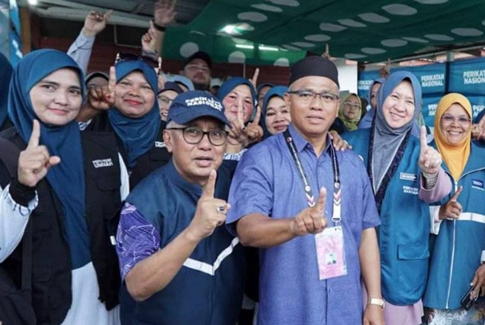 Ismail bersama calon Perikatan Nasional (PN) Kasim Samat ketika membantu kempen bertemu peniaga di pasar malam Simpang Pelangai di sini.