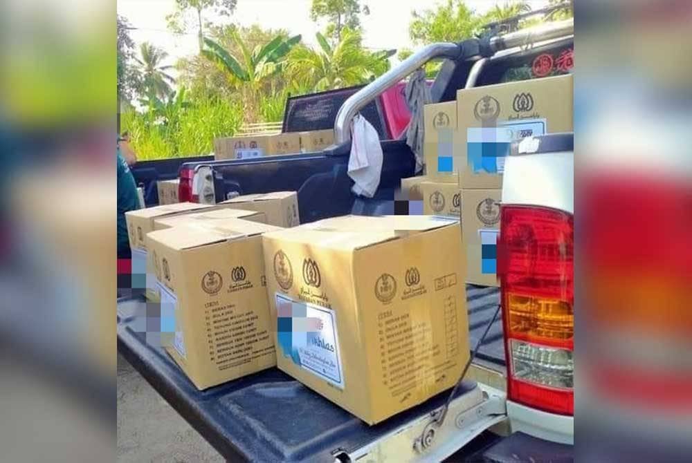 Gambar tular yang menunjukkan kotak makanan Yayasan Perak ditampal pelekat individu sebelum diagihkan kepada penerima bantuan tersebut.