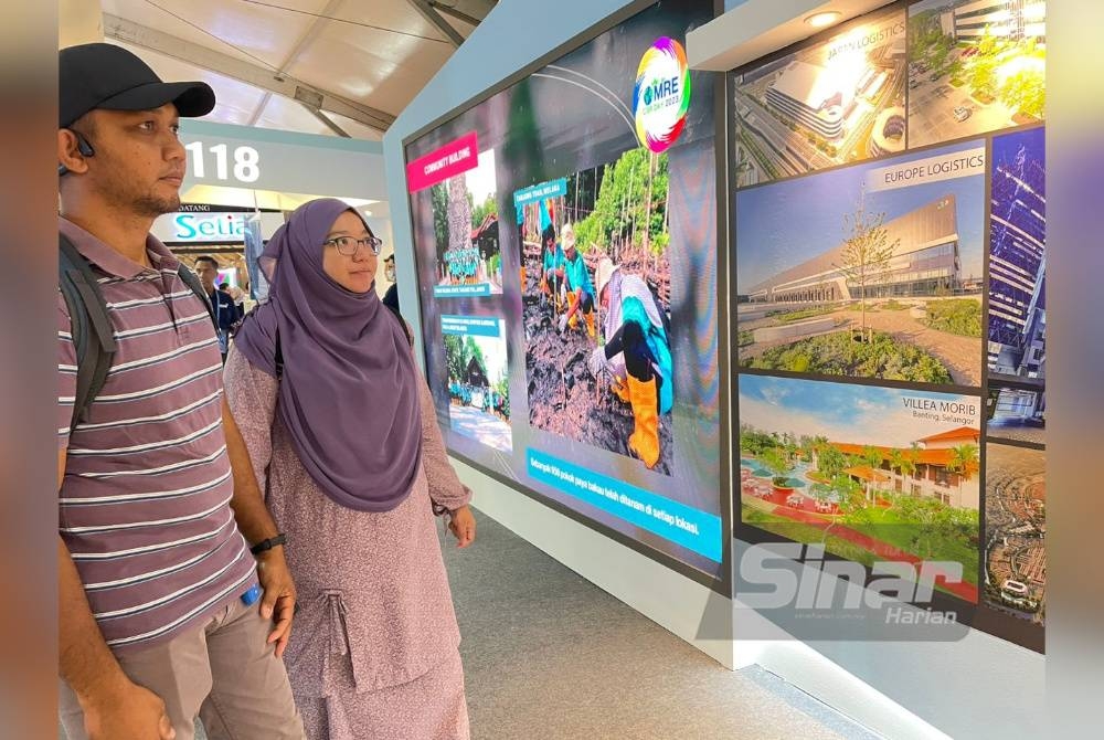 Anis dan Abu Hanafi melihat maklumat yang disediakan di salah sebuah reruai di MSAM 2023.