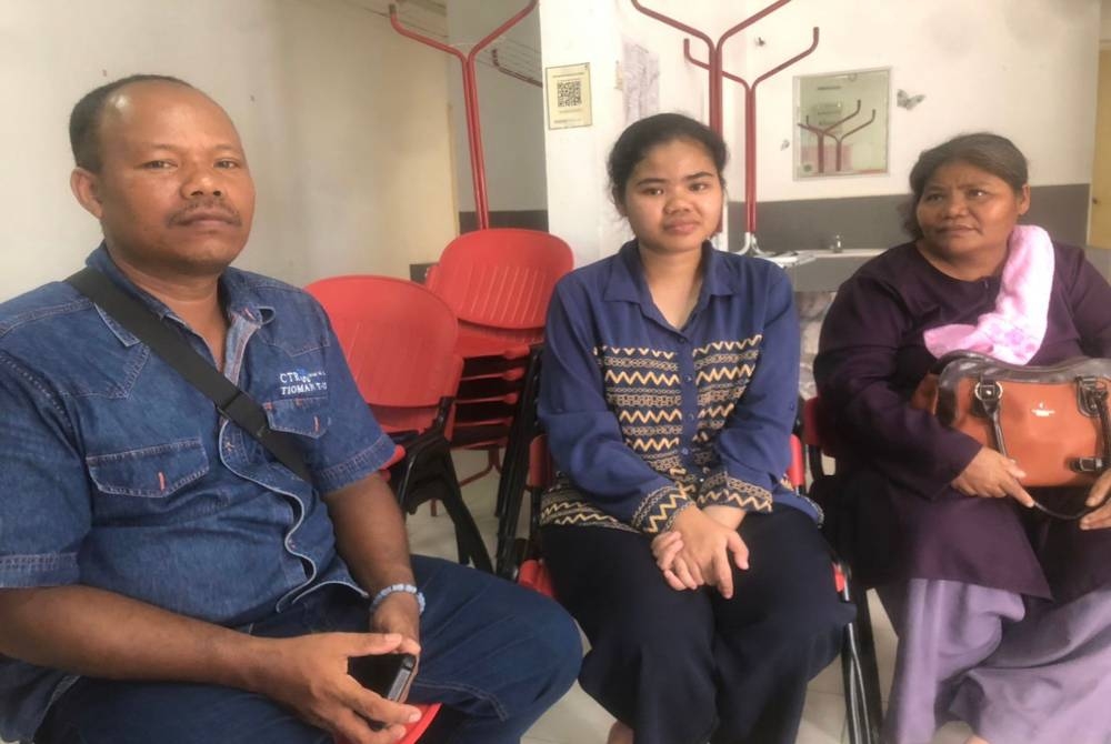 Fida Adira (tengah) bersama ibu bapanya iaitu Eron (kiri) dan Fatimah (kanan) yang hadir di UMK, Bachok pada Ahad.