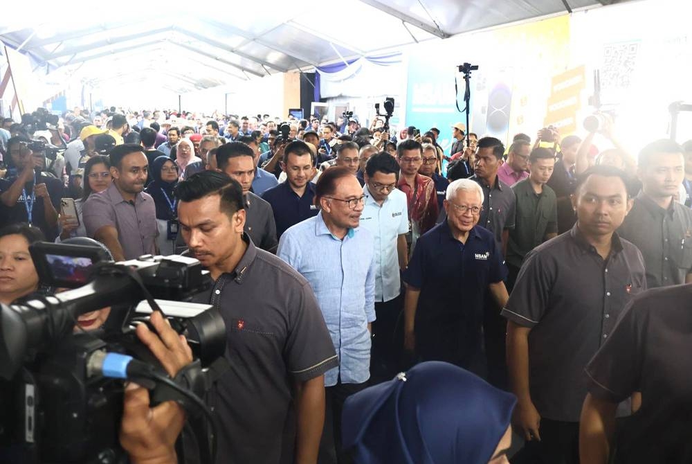 Anwar (tengah) diiringi Raja Arshad ketika menghadiri MSAM 2023 pada Ahad.