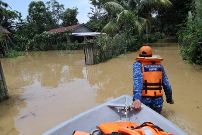 Anggota Angkatan Pertahanan Awam (APM) Kota Setar menjalankan operasi menyelamat mangsa-mangsa banjir dari Kampung Bukit, Mukim Derang. - Foto Bernama