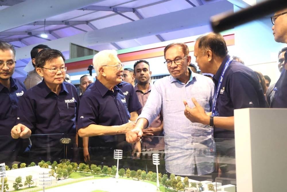 Raja Arshad (tiga dari kiri) menerangkan mengenai pameran kepada Anwar ketika sesi lawatan ke reruai MSAM 2023.