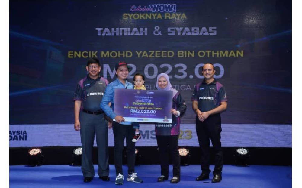 Norliza (dua dari kanan) menyerahkan hadiah cabutan ‘Siri Wow! Syoknya Raya PTPTN’ kepada Mohd Yazeed (dua dari kanan) sempena BMS 2023 di Sunyaw Pyramid Mall, Petaling Jaya pada Ahad.
