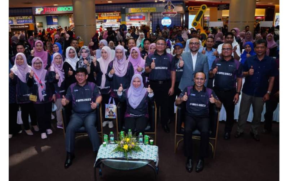 Norliza (duduk,tengah) menunjukkan isyarat bagus bersama-sama warga PTPTN dan para pengunjung BMS 2023.