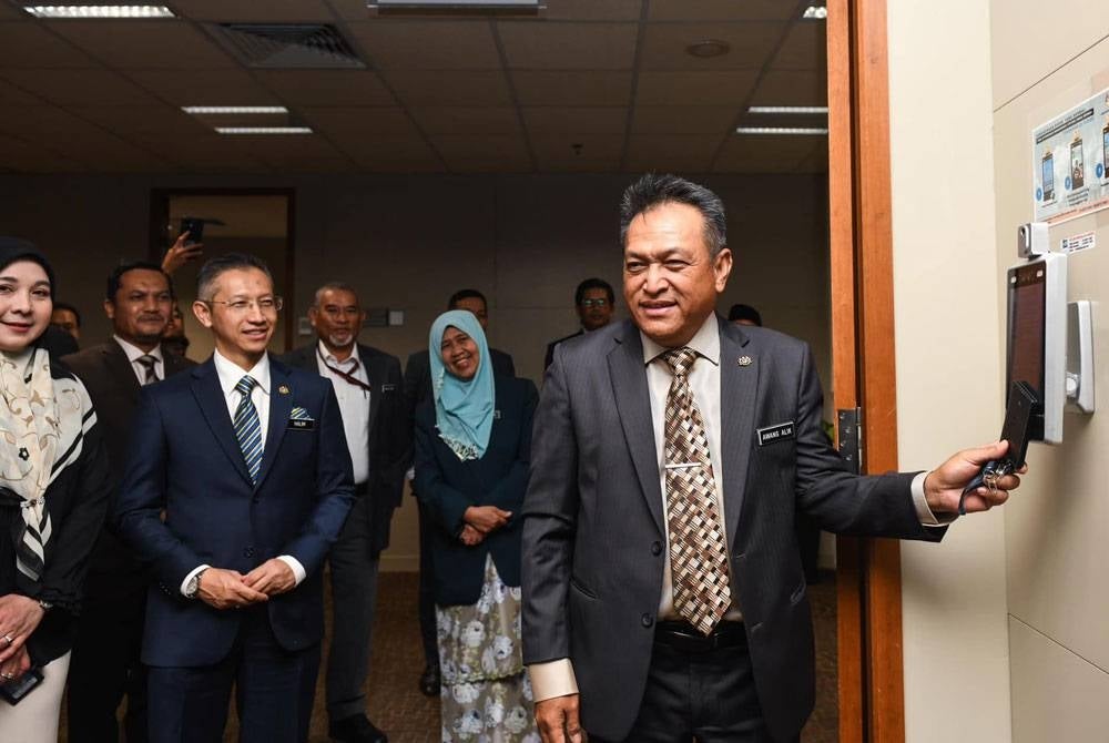 Awang Alik (kanan) dan Abdul Halim (dua dari kiri) semasa sesi 'clock in' di Jabatan Perdana Menteri, pada pagi Isnin. - Foto Facebook JPM