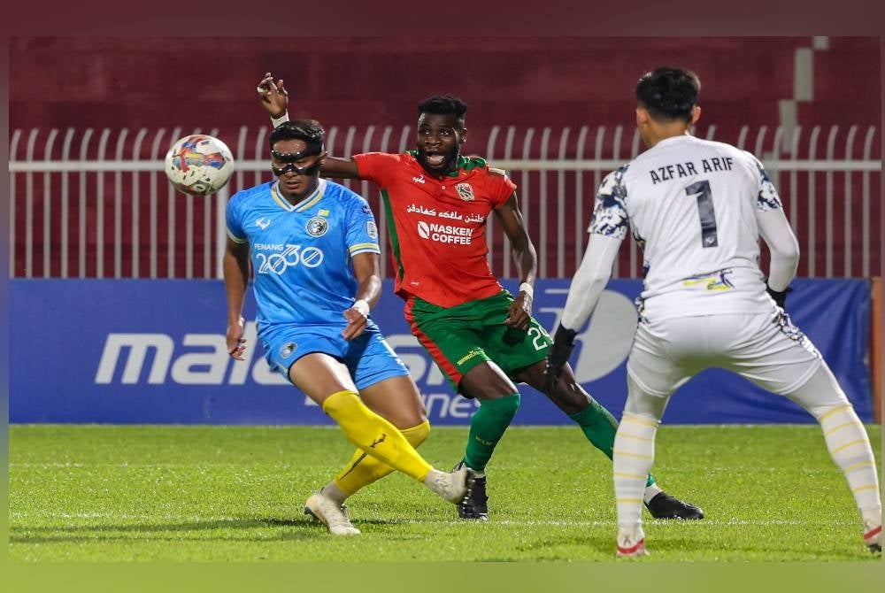 Pemain Kelantan United FC, Ismaheel Akinade (tengah) dihalang pemain Penang FC Asnan Ahmad (kiri) dalam aksi perlawanan Liga Super di Stadium Sultan Muhammad Ke-IV di sini malam tadi. - Foto Bernama