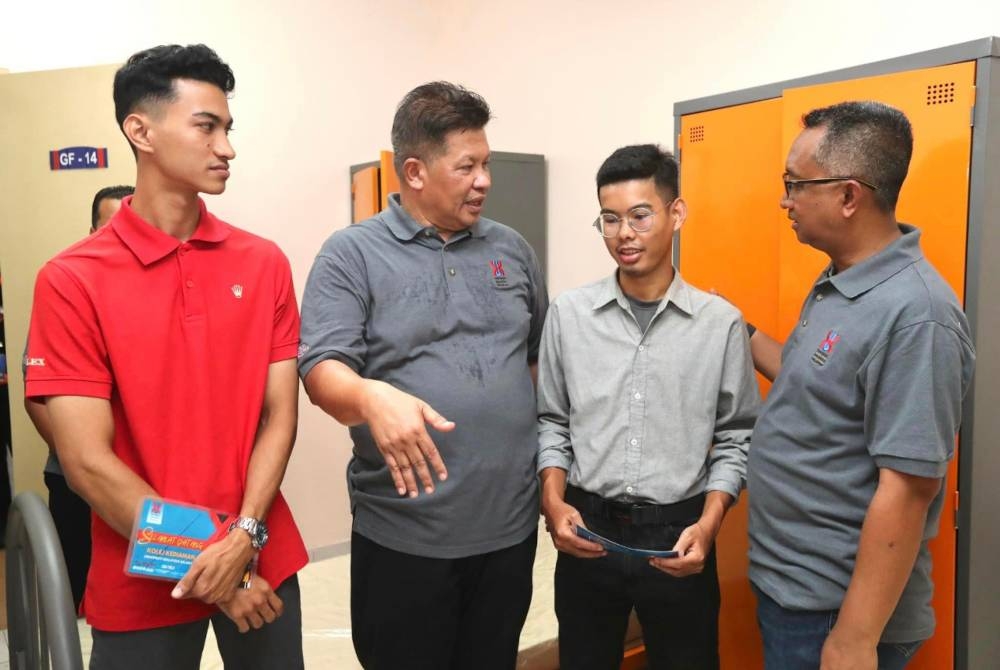 Dr Razli (dua dari kiri) menyampaikan sumbangan kepada OKU penglihatan yang baharu mendaftar ke UMK.