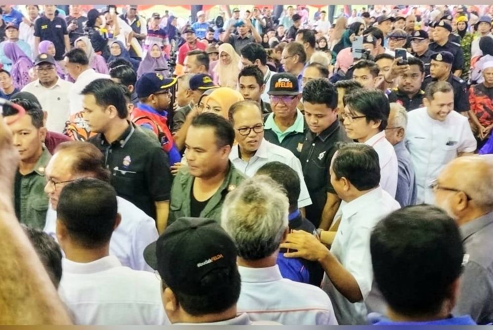 Wan Rosdy (tengah) ketika tiba bersama Anwar dalam karnival tersebut di Felda Chemomoi di Bentong pada Isnin.