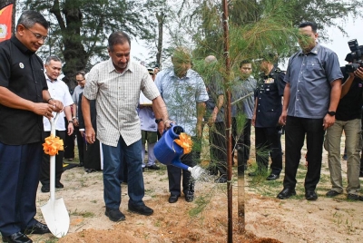 Sultan Terengganu Sultan Mizan Zainal Abidin (dua, kiri) berkenan menyiram selepas menanam pokok rhu pada Majlis Perasmian Penanaman Pokok di Pantai Batu Burok, pada Isnin. - Foto Bernama