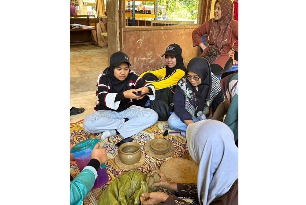 Pelancong diberi peluang menghasilkan tembikar daripada tanah liat.