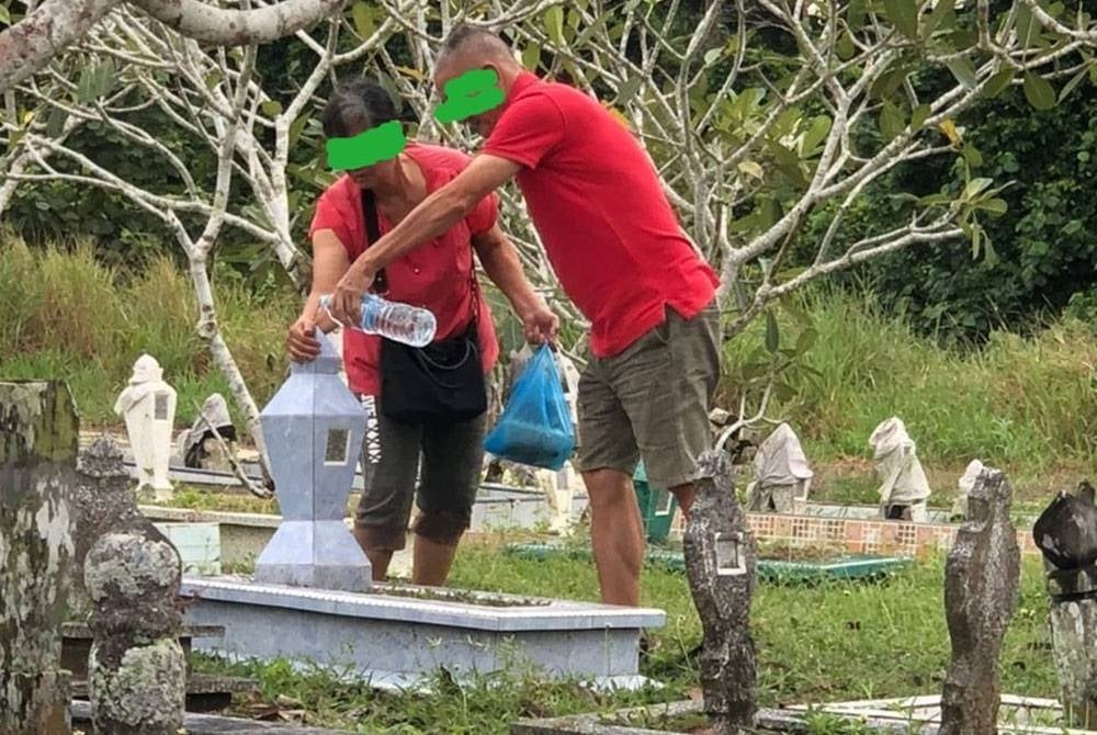 GAMBAR pasangan suami isteri yang tular menziarahi pusara anak mereka walaupun berlainan agama.
