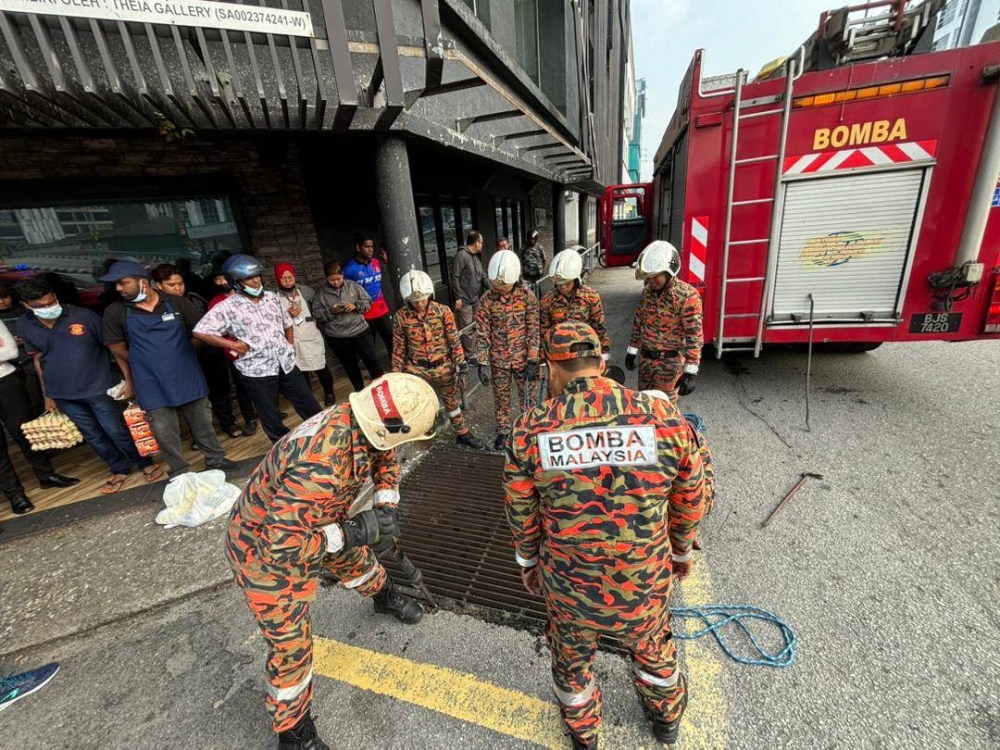 Anggota bomba menjalankan kerja mengeluarkan mangsa yang terperangkap dalam longkang dalam kejadian di Jalan Tun Abdul Aziz, di sini pada Selasa.