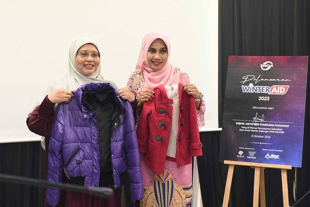 Siti Sakinah (kiri) bersama Datin Seri Masdiana Muhamad menunjukkan baju sejuk yang akan disumbangkan kepada masyarakat Utara Syria dan Lubnan.