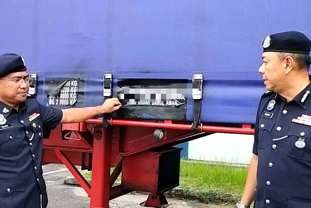 Rahmat (kanan) melihat pelekat nama syarikat yang telah ditukar pada sidang akhbar di IPD Iskandar Puteri.