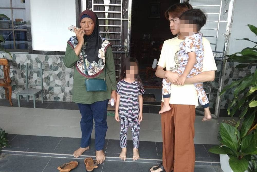 Suraidah (kiri) bersama anaknya Aiman ( kanan) selamat tiba di rumah mereka di Kluang dari Terengganu pada Selasa.