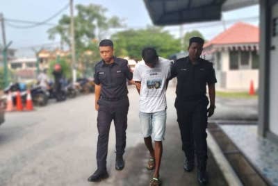 Tertuduh diiringi anggota polis di mahkamah atas pertuduhan miliki dadah.