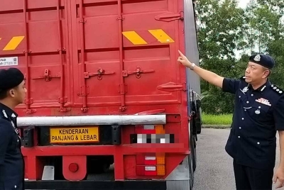 Rahmat (kanan) menunjukkan warna ekor treler yang diubah cat kepada warna merah pada sidang akhbar di IPD Iskandar Puteri pada Selasa.