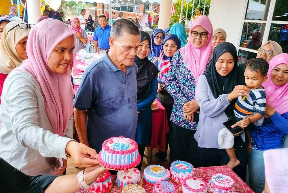 Adnan (dua dari kiri) sempat meluangkan masa menjadi juri kek dalam program di Kampung Semerting pada Rabu.