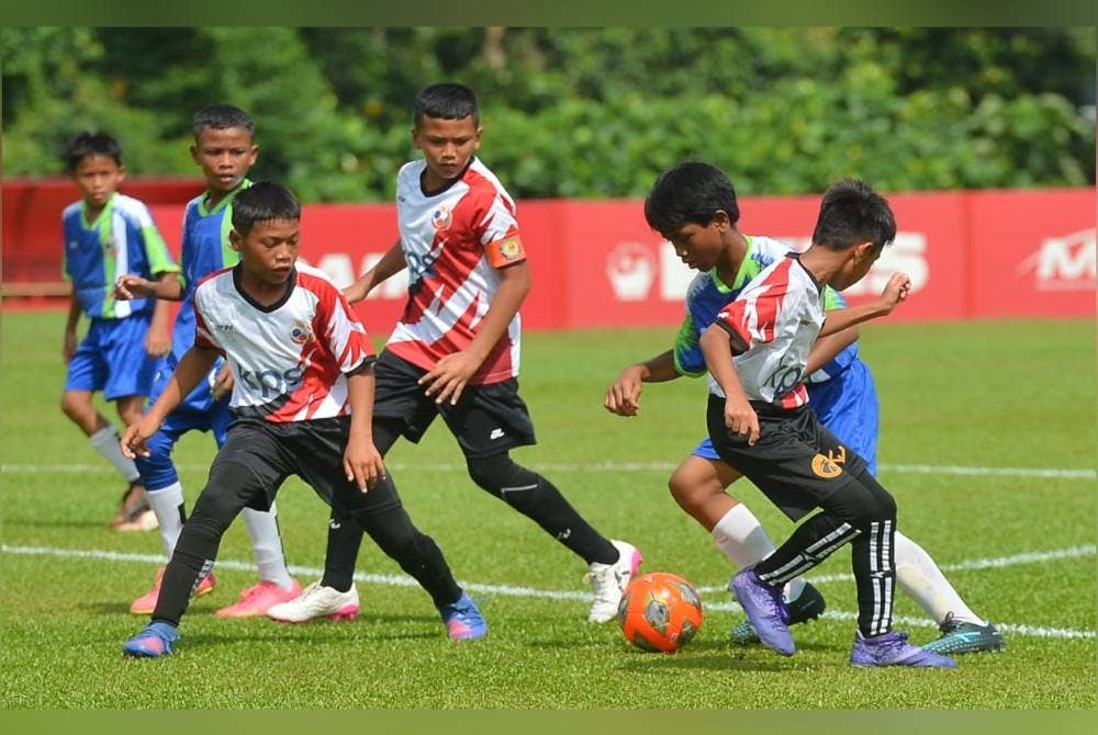 Pemain SK Taman Alam Megah berusaha mengekang kelincahan pemain SK Seksyen 20 dalam perlawanan akhir Piala Raja Muda Selangor di padang Latihan Persatuan Bolasepak Selangor FAS.