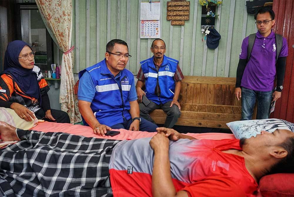 Amizar (dua dari kiri) ketika menyantuni penduduk di Felda Kemahal, Bentong pada Khamis.