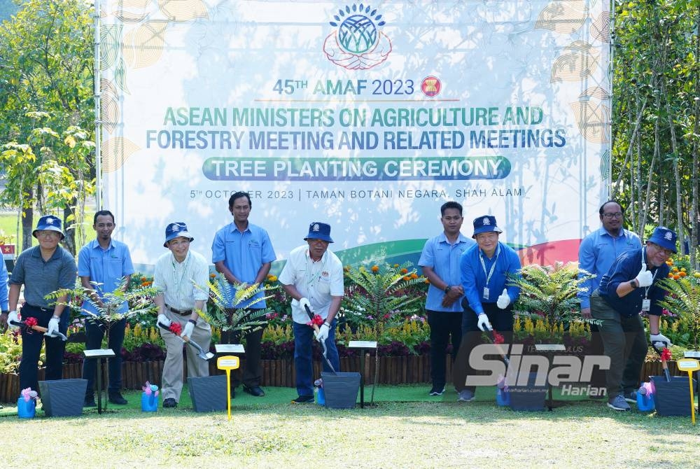 Mohamad (tengah) bersama delegasi menyempurnakan aktiviti penanaman 14 Pokok Tongkat Ali ketika lawatan ke Taman Botani Negara Shah Alam sempena AMAF ke-45 pada Khamis. - Foto Sinar Harian MOHD HALIM ABDUL WAHID