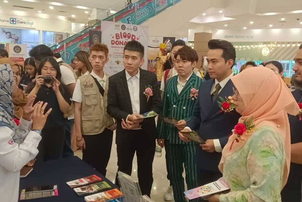 Masrudi (belakang, kanan ) dan Enny Suhailis (depan) melawat reruai pameran Pertubuhan Keselamatan Sosial Johor.