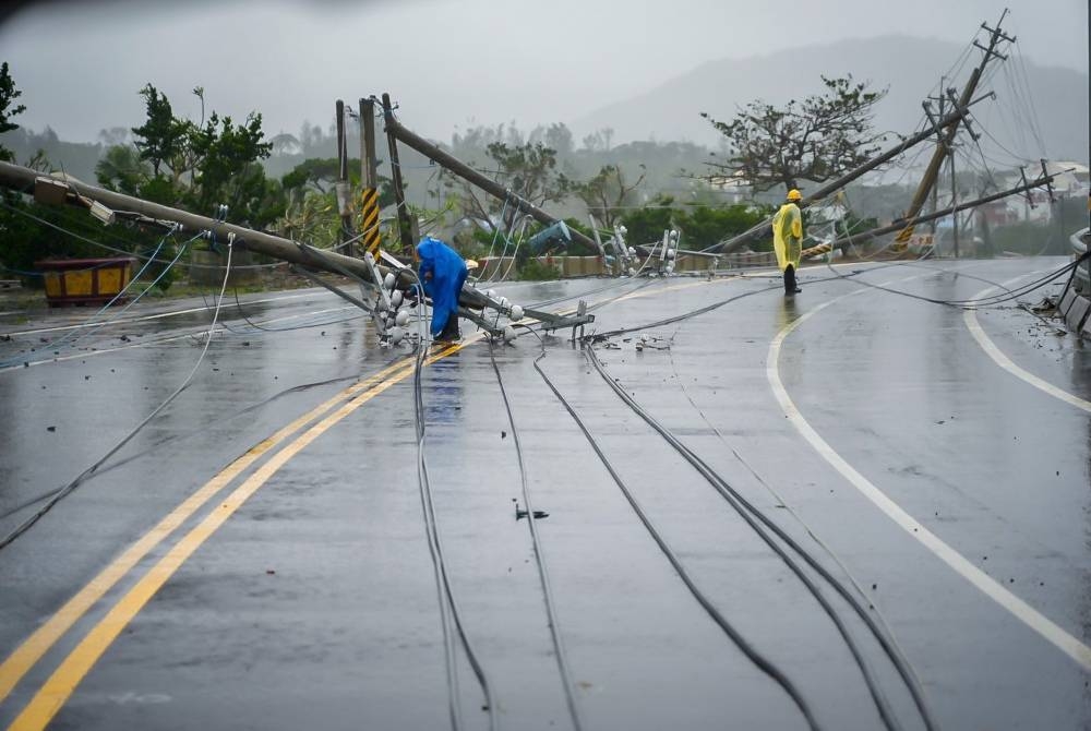 Pekerja membaiki talian elektrik rosak yang dibawa oleh taufan Koinu di daerah Pingtung, Selatan Taiwan. - Foto EPA