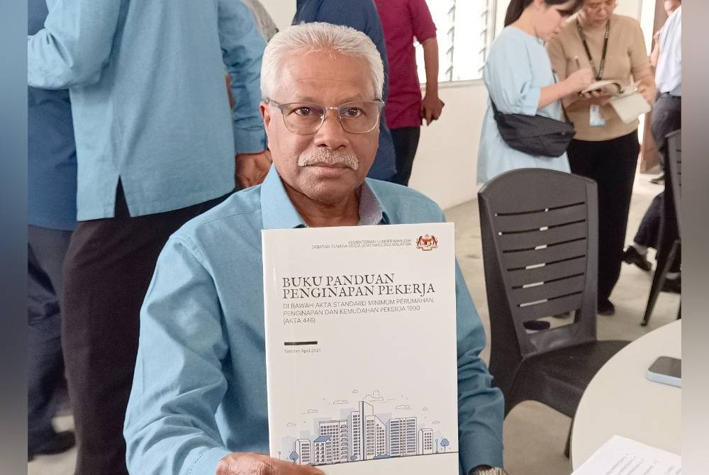 Sivanesan menunjukkan buku panduan penginapan pekerja yang dirujuk bagi menyelesaikan isu penempatan warga asing di pangsapuri D'Aman Residensi, Meru Raya.