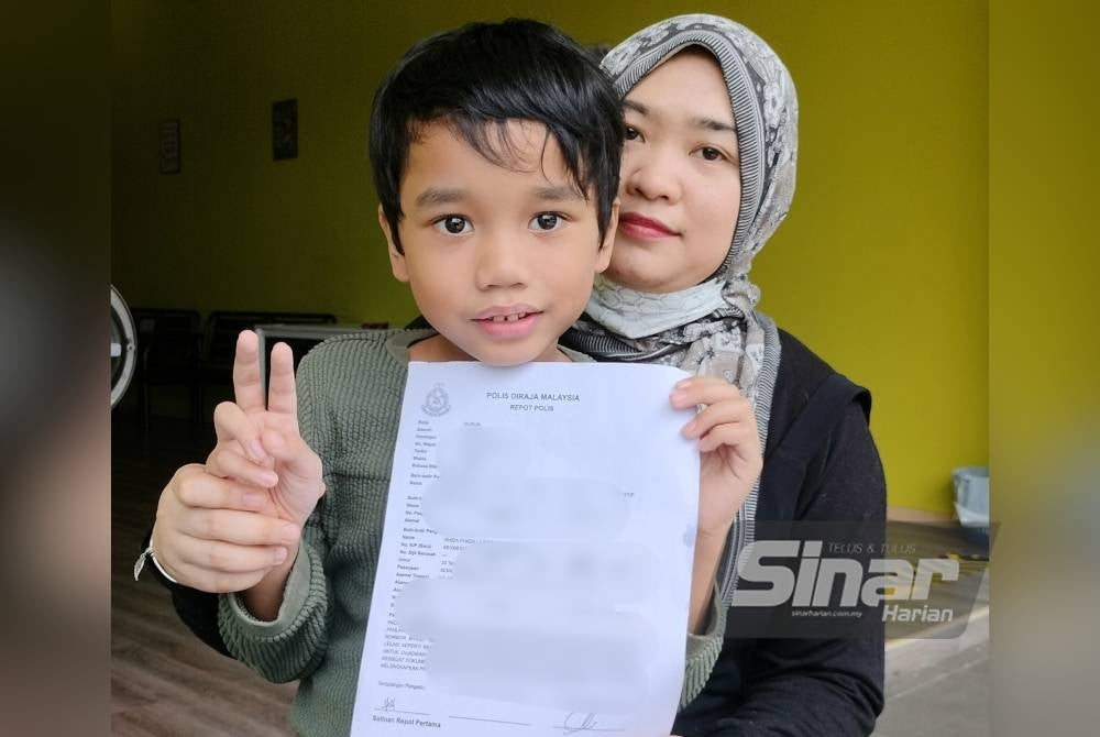 Rhida Fhadilla menunjukkan laporan polis yang dibuat mengenai penyerahan Adam Afiq pada 2016.