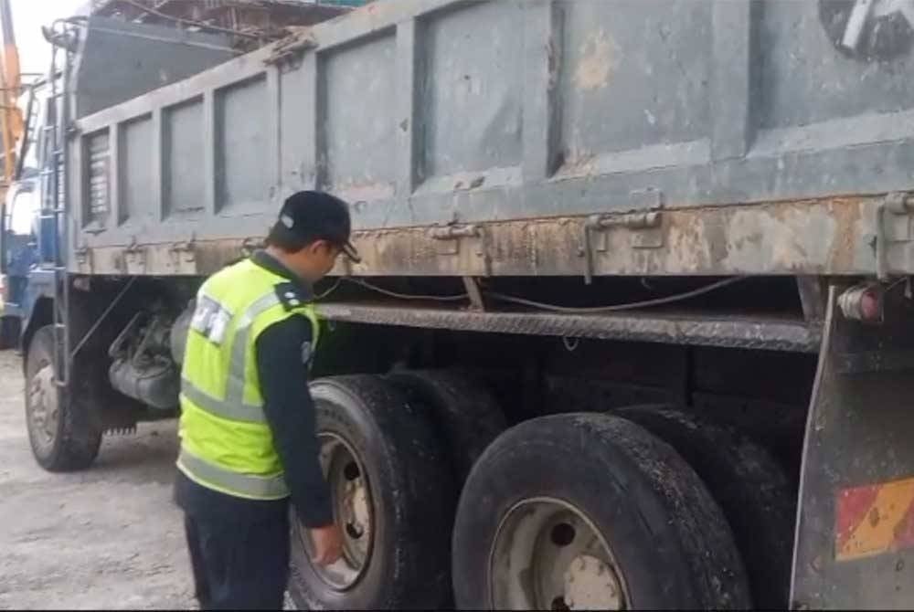 Anggota JPJ Kuala Lumpur memeriksa tayar sebuah lori dipandu warga asing dari Pakistan yang telah haus berlebihan atau botak semasa ditahan di MRR2 pada Jumaat.