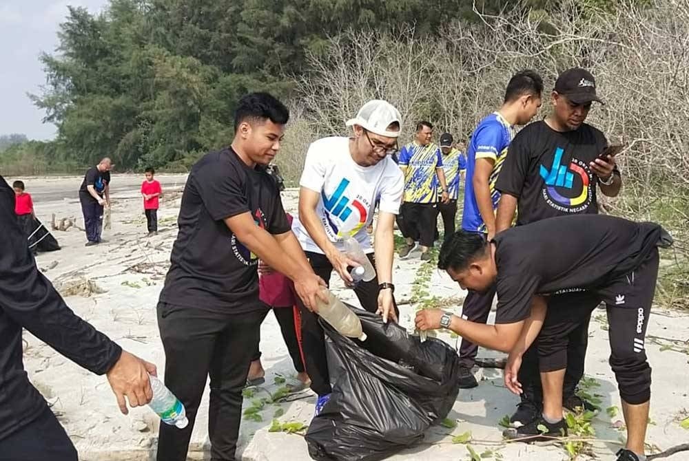 Razaman (tiga dari kiri) bersama sebahagian peserta Program FitDOSM Perdana melakukan aktiviti pembersihan pantai di Taman Gelora di sini pada Sabtu.