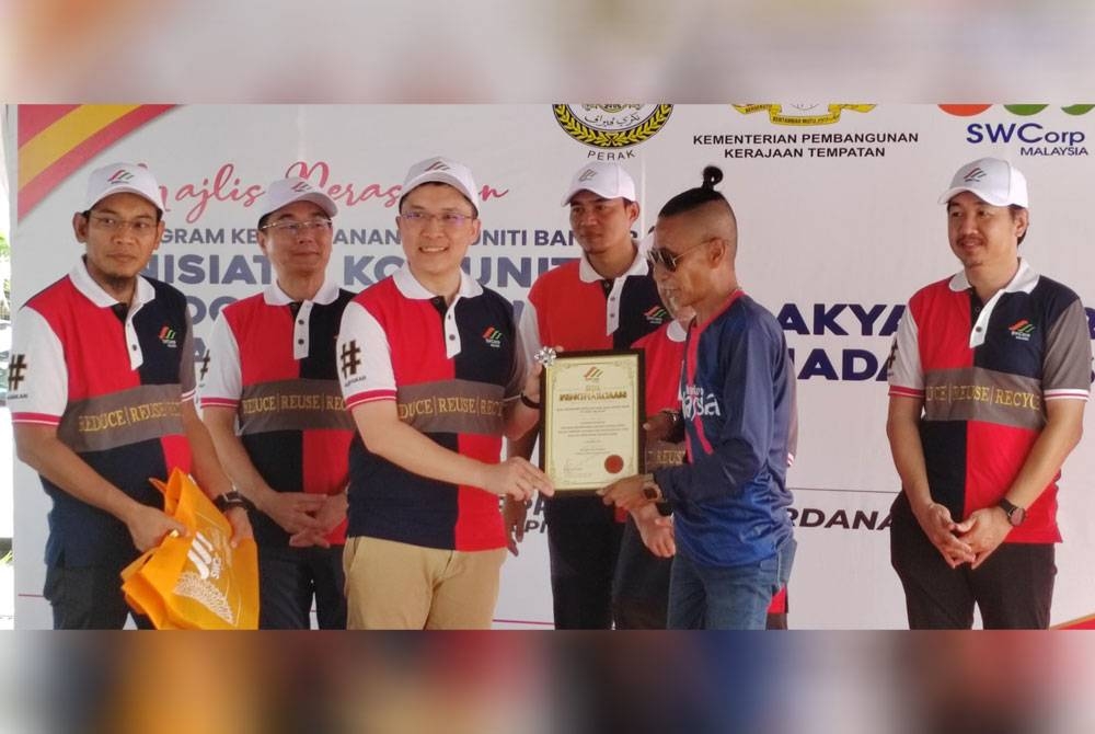 Kah Woh (tiga dari kiri) menyerahkan watikah pelantikan Ikon 3R komuniti, Wan Mohamad Suhaimi Wan Mohd Amin, 52, pada program PKKB Inisiatif Komuniti PPR SSBM di PPR Simpang Perdana, Taiping pada Sabtu.
