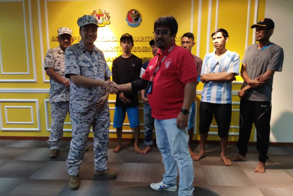 Nurul Hizam (kiri) menyerahkan lima pemancing warga Indonesia yang diselamatkan selepas bot karam kepada Konsulat Jenderal Republik Indonesia Johor Bahru pada Sabtu.