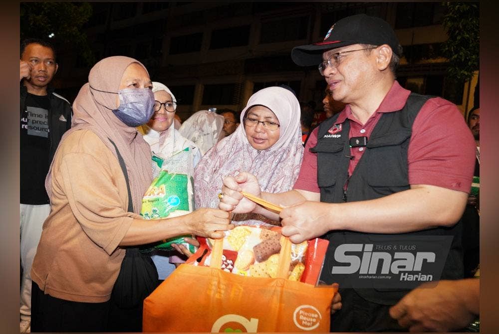 Mohd Na'im menyatakan sesuatu kepada seorang penerima bantuan ketika Program Jejak Gelandangan dilaksanakan MAIWP. - Foto Sinar Harian/ROSLI TALIB