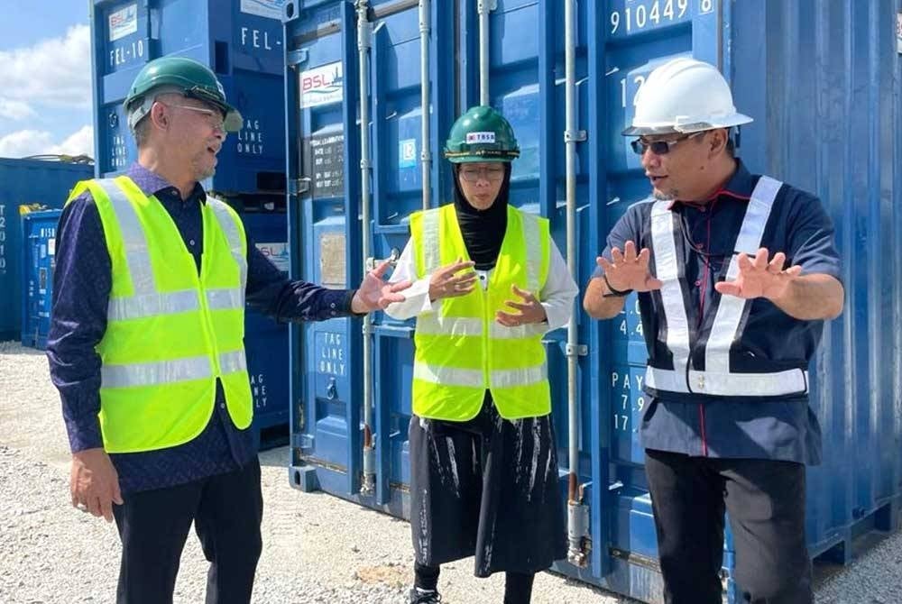 Nur Hasmin (kanan) memberi penerangan kepada Fauziah (tengah) dan Nor Sham (kiri) ketika lawatan melihat kontena luar persisir di TBSB di Tok Bali, Pasir Puteh.