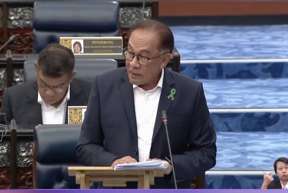 Anwar memakai riben hijau sebagai simbolik kepada kesedaran kesihatan mental di Beliau yang turut memakai riben hijau sebagai simbolik kepada kesedaran kesihatan mental di Dewan Rakyat. - Foto Bernama