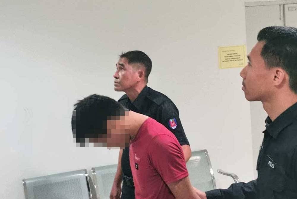 Tertuduh (tengah) ketika dihadapkan ke Mahkamah Sesyen di Kuala Terengganu pada Khamis lalu.