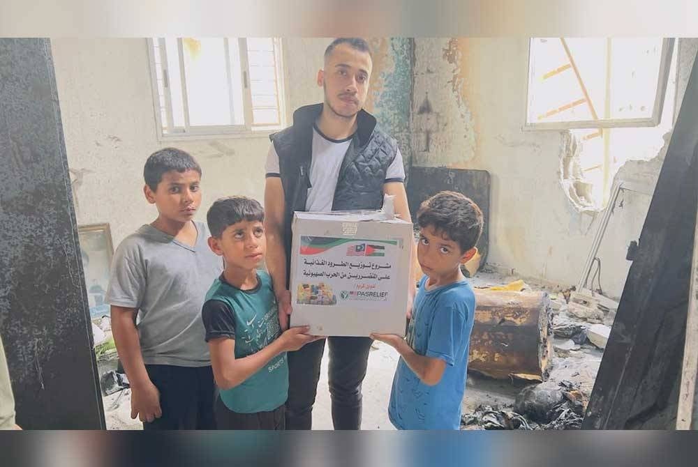 Wakil PASRelief mengagihkan sumbangan kepada penduduk Palestin.
