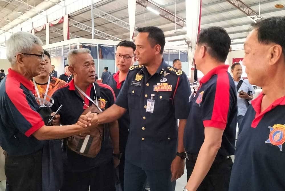 Nor Hisham (tengah) berbual dengan beberapa anggota PBS selepas Majlis Perasmian Penutupan Konvensyen PBS Zon Utara 2023 di Balik Pulau pada Selasa.