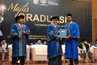Ahmad Hamdi (kiri) mengiringi penyampaian skrol kepada graduan disempurnakan Rohayah (dua dari kiri) kepada graduan pada Majlis Graduasi GiatMara Malaysia Ke-36 bagi Zon Utara di Alor Setar pada Selasa.