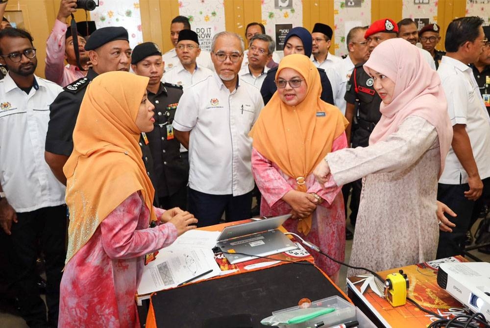 Fadhlina (kanan) berbual dan bertanya sesuatu kepada salah seorang guru semasa melawat kelas di Sekolah Integriti Pusat Koreksional Puncak Alam, di sini pada Rabu.