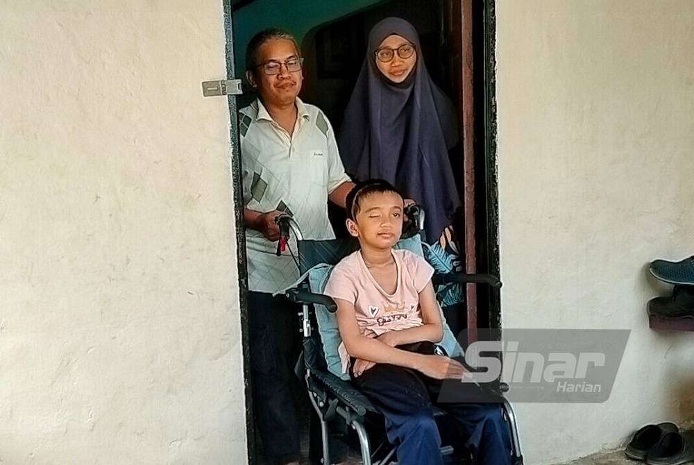 Naira Mahdeeya (tengah) terpaksa bergerak menggunakan kerusi roda kerana kaki kirinya mengalami strok.