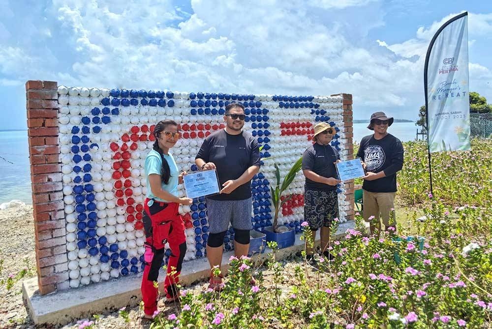 Khairil Anuar (dua dari kanan) menyerahkan plak penghargaan kepada mereka yang terlibat dalam prorgam Pembersihan Pantai Antarabangsa 2023 (ICCMY2023).