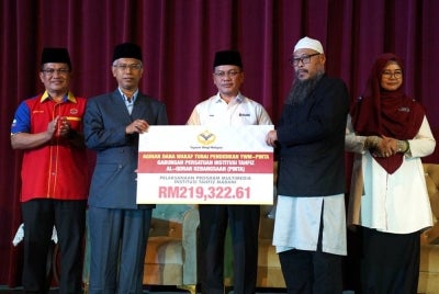 Ridzwan (dua dari kiri) menyampaikan sumbangan kepada Zulkifli (dua dari kanan) dalam Majlis Perhimpunan Agensi di bawah Jabatan Perdana Menteri (Hal Ehwal Agama) di Dewan Serbaguna Masjid Wilayah Persekutuan Kuala Lumpur pada Rabu.