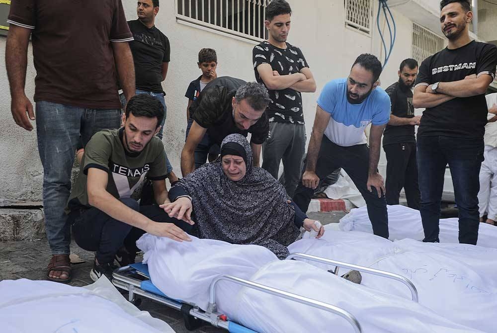 Seorang wanita meratapi jenazah ahli keluarganya yang maut dalam serangan Israel di Hospital Al-Shefa di Kota Gaza. - Foto EPA