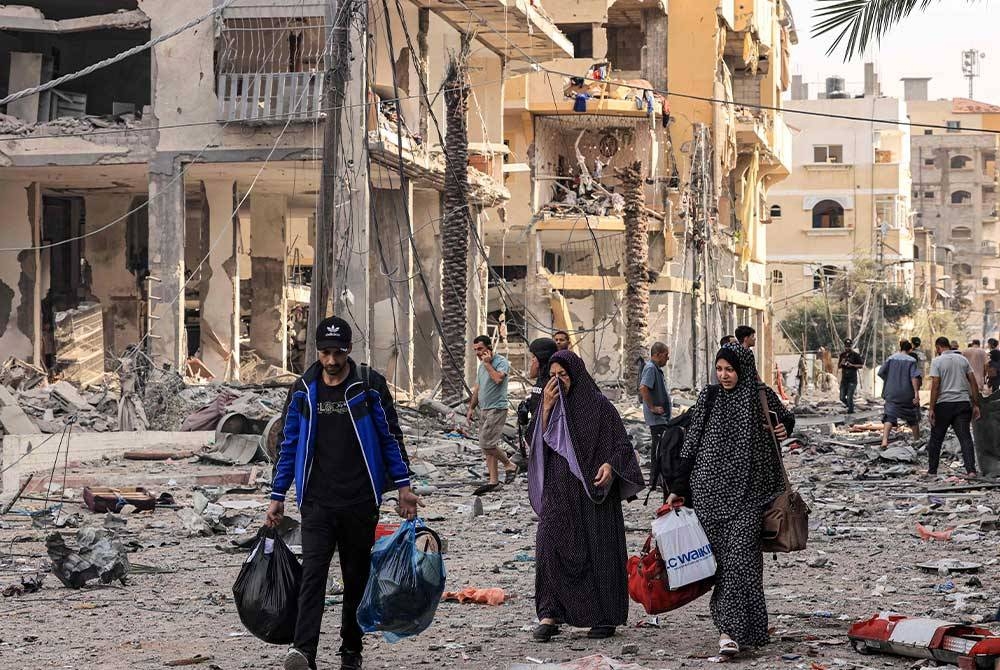 Penduduk Palestin meninggalkan kawasan kejiranan al-Karama di Bandar Gaza ke kawasan yang lebih selamat. - Foto AFP