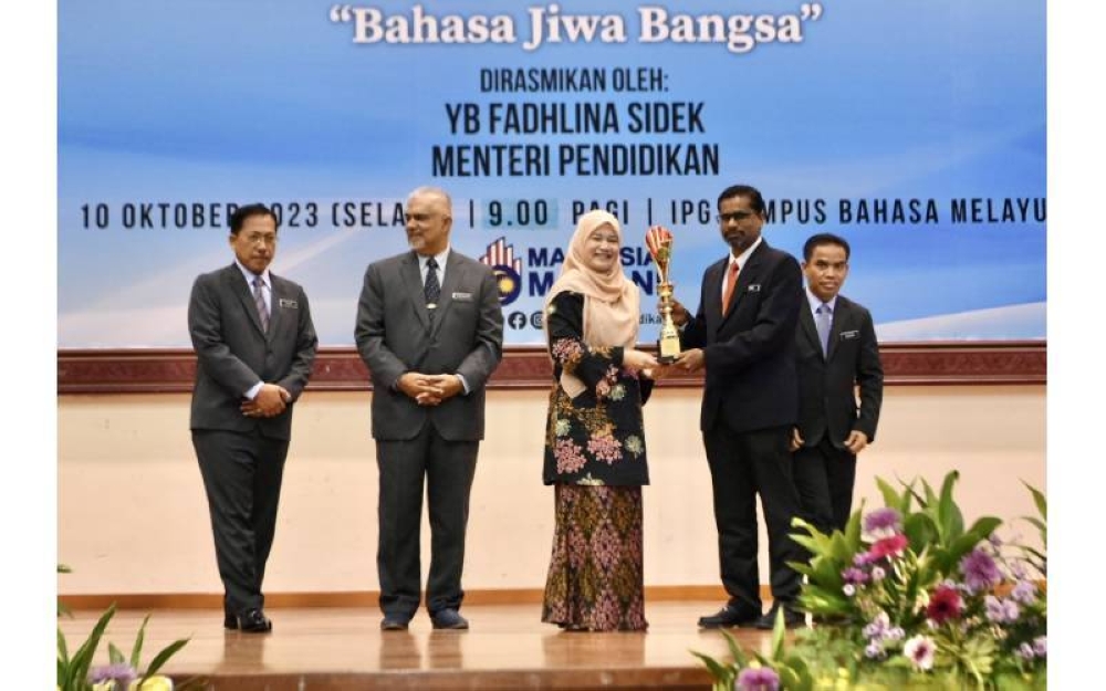Fadhlina (tiga, kiri) menyerahkan Anugerah Tokoh Bahasa Melayu Sektor Pendidikan Kategori Teknik Vokasional kepada Dr Siva sempena MSDBKSP 2023. 