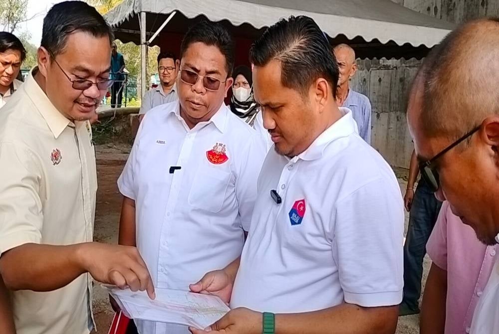 Mohamad Fazli (kanan) mengadakan pertemuan dengan jabatan berkaitan berhubung jambatan utiliti di Kampung Perigi Acheh, Pasir Gudang.