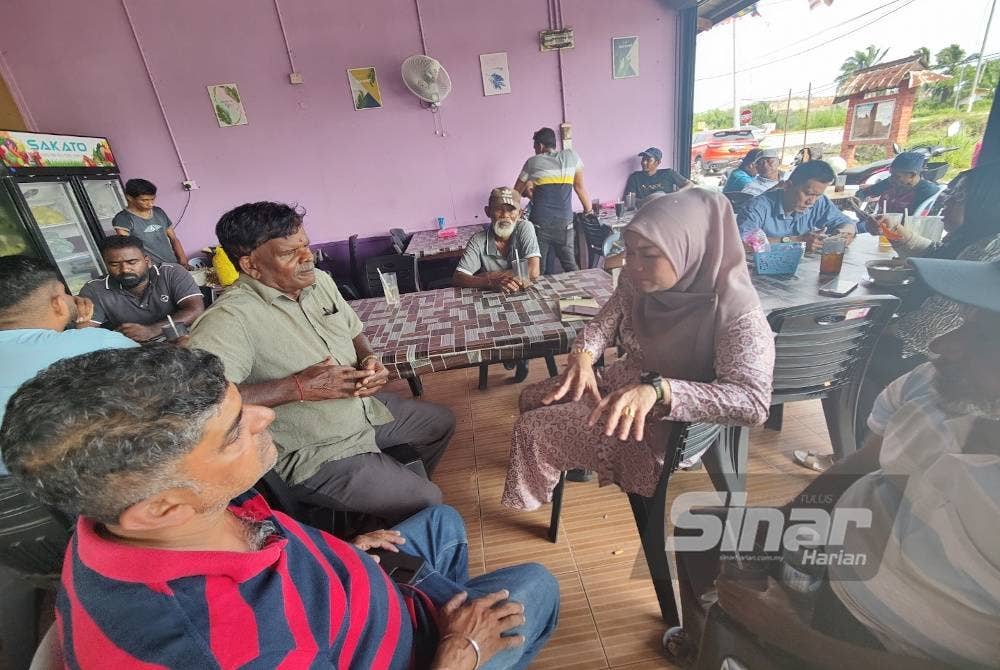 Nurul Syazwani (kanan) berbincang bersama peneroka di sebuah kedai makan selepas tidak dibenarkan masuk ke dalam Balai MPKK Raja Musa pada Rabu.